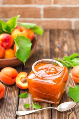 Bir kavanoz ve yaprakları ile taze meyveler kayısı