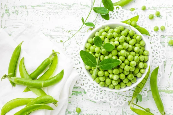 Green peas with leaves on white background — Stock Photo, Image