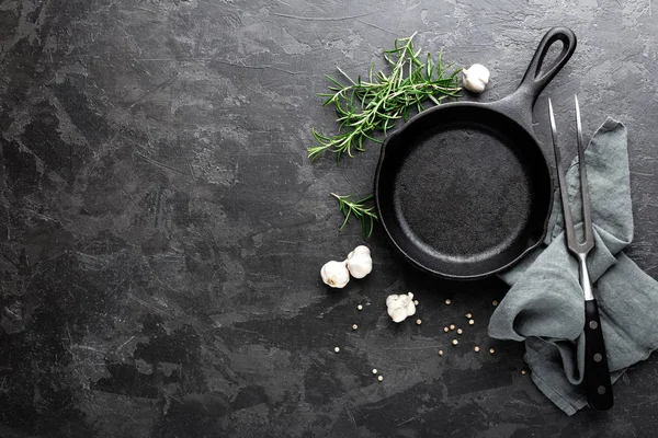 Пустая чугунная сковородка на темно-сером кулинарном фоне, вид сверху — стоковое фото