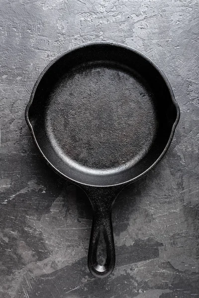 空の暗い灰色の料理の背景の鋳鉄製フライパン、上からの眺め — ストック写真