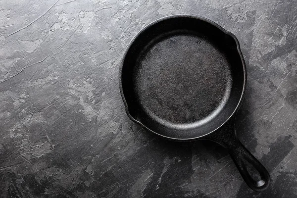 Sartén vacía de hierro fundido sobre fondo culinario gris oscuro, vista desde arriba — Foto de Stock