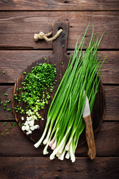 Oignon vert ou échalote sur planche de bois, ciboulette de printemps fraîche — Photo