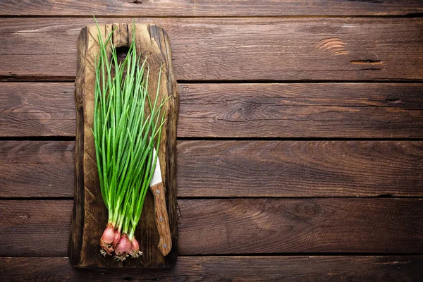 Cebolla verde o cebolleta en tabla de madera, cebolletas frescas de primavera —  Fotos de Stock