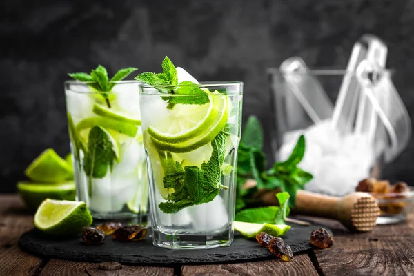 Refrescante cóctel de menta mojito con ron y lima, bebida fría o bebida con hielo sobre fondo negro —  Fotos de Stock