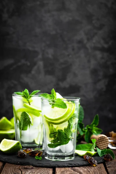Verfrissende munt cocktail mojito met rum en limoen, koude drank of drank met ijs op zwarte achtergrond — Stockfoto