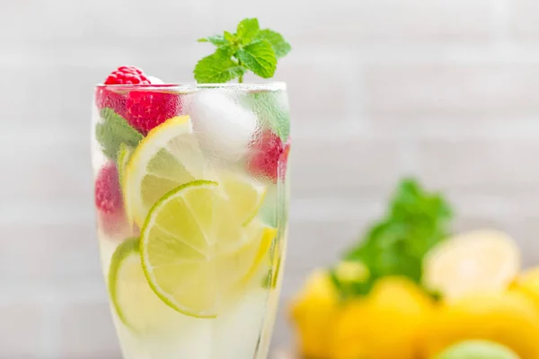 Coctel mojito de limón con lima, menta y frambuesa, bebida fría con hielo . — Foto de Stock