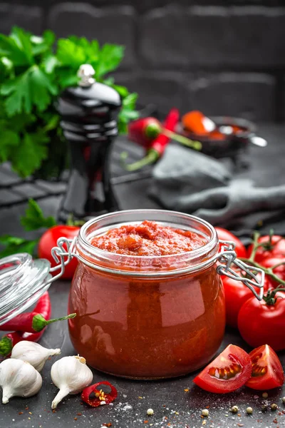 Molho de tomate em jarra de vidro e tomates frescos — Fotografia de Stock