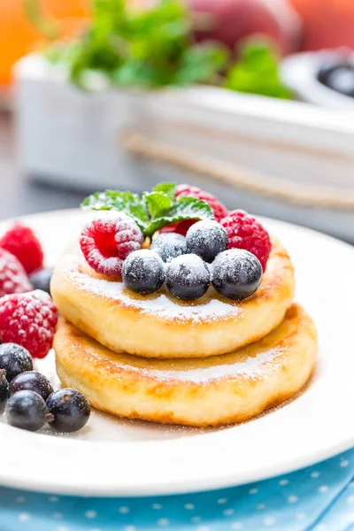 Panqueques de requesón, syrniki, buñuelos de cuajada con bayas —  Fotos de Stock