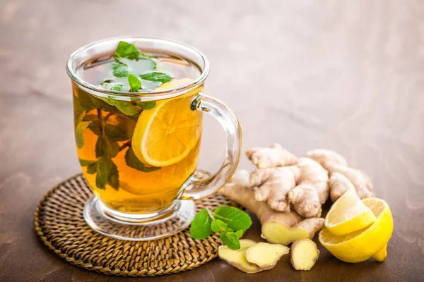 热的草本茶与新鲜的柠檬 生姜和薄荷叶子在褐色背景 — 图库照片