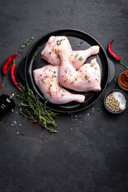 Çiğ tavuk çeyrek, karanlık bir arka plan üzerinde bir tavada bacaklar. Üstten Görünüm.