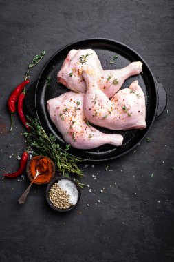 Çiğ tavuk çeyrek, karanlık bir arka plan üzerinde bir tavada bacaklar. Üstten Görünüm.