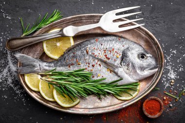 Taze çiğ dorado balık siyah arka plan, üstten görünüm