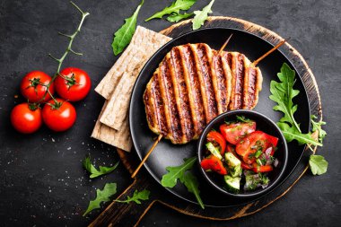 Sulu ızgara tavuk eti şiş üzerinde lula kebabı siyah arka plan, üstten görünüm taze sebze salatası