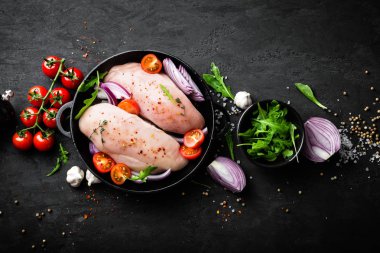Taze çiğ tavuk eti, baharat, soğan ve domates siyah arka plan üzerinde Marine fileto. Üstten Görünüm