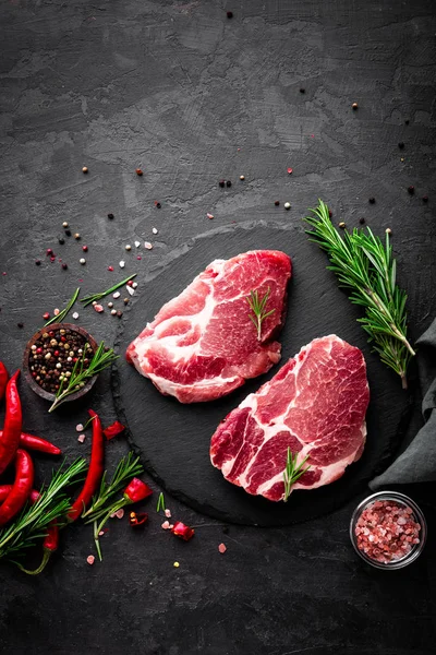 Syrové Vepřové Maso Čerstvé Steaky Břidlicové Desce Černém Pozadí Horní — Stock fotografie