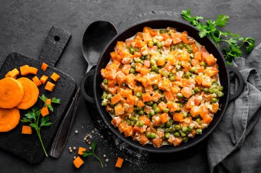 Kremalı süt sos güveç, siyah arka plan, üstten görünüm üzerinde sebze sote taze yeşil bezelye ile havuç kızarmış