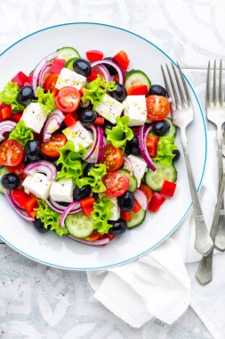 Taze salatalık, domates, tatlı biber, marul, kırmızı soğan, beyaz peynir ve zeytin zeytinyağı ile Yunan salatası. Sağlıklı vejetaryen yemek