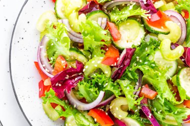 Salata taze salatalık, kereviz, tatlı biber, frize marul, kırmızı soğan ve susam yağı. Sağlıklı vejetaryen, vegan gıda. İtalyan mutfağı