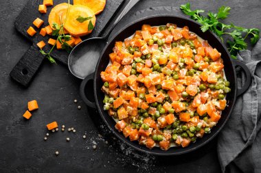 Kremalı süt sos güveç, siyah arka plan, üstten görünüm üzerinde sebze sote taze yeşil bezelye ile havuç kızarmış