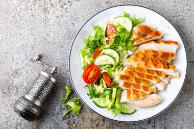 Tavuk göğsü veya fileto, ızgara kanatlı eti ve taze sebze salatası, domates, salatalık ve marul. Öğle yemeği için sağlıklı beslenme menüsü