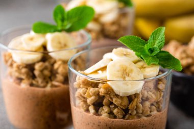 Muz, granola ve yoğurt, tatlı çikolata chia puding parfe katmanlı