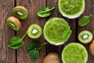 Kivi güler yüzlü bardak ıspanak yaprakları ve ahşap rustik tablo, sağlıklı detoks diyet taze meyve 