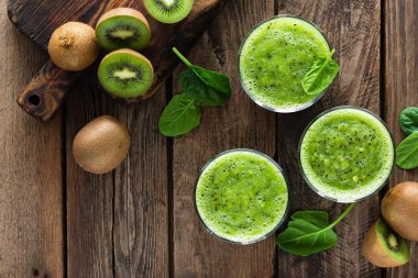 Kivi güler yüzlü bardak ıspanak yaprakları ve ahşap rustik tablo, sağlıklı detoks diyet taze meyve 