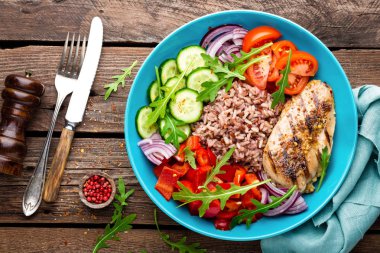 Izgara tavuk göğsü. Kızarmış tavuk fileto ve domates, salatalık, biber, marul ve roka yaprakları taze sebze salatası. Salata tavuk eti. Sağlıklı gıda. Düz yatıyordu. Üstten Görünüm. Ahşap arka plan
