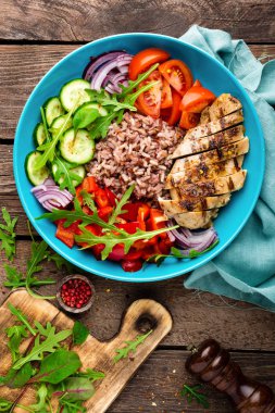 Izgara tavuk göğsü. Kızarmış tavuk fileto ve domates, salatalık, biber, marul ve roka yaprakları taze sebze salatası. Salata tavuk eti. Sağlıklı gıda. Düz yatıyordu. Üstten Görünüm. Ahşap arka plan