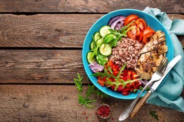 Izgara tavuk göğsü. Kızarmış tavuk fileto ve domates, salatalık, biber, marul ve roka yaprakları taze sebze salatası. Salata tavuk eti. Sağlıklı gıda. Düz yatıyordu. Üstten Görünüm. Ahşap arka plan