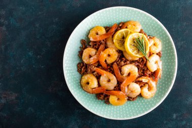 Karides ızgara kavrulmuş ve plaka üzerinde kahverengi pirinç haşlanmış. Izgara karides, karides pirinç. Deniz ürünleri. Asya mutfağı. Üstten Görünüm. Koyu arka plan