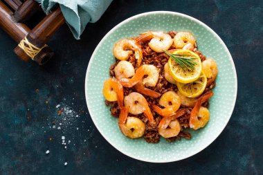 Karides ızgara kavrulmuş ve plaka üzerinde kahverengi pirinç haşlanmış. Izgara karides, karides pirinç. Deniz ürünleri. Asya mutfağı. Üstten Görünüm. Koyu arka plan