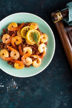 Karides ızgara kavrulmuş ve plaka üzerinde kahverengi pirinç haşlanmış. Izgara karides, karides pirinç. Deniz ürünleri. Asya mutfağı. Üstten Görünüm. Koyu arka plan