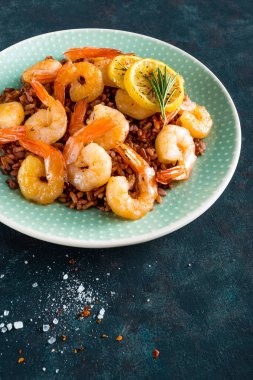 Karides ızgara kavrulmuş ve plaka üzerinde kahverengi pirinç haşlanmış. Izgara karides, karides pirinç. Deniz ürünleri. Asya mutfağı. Portre. Koyu arka plan