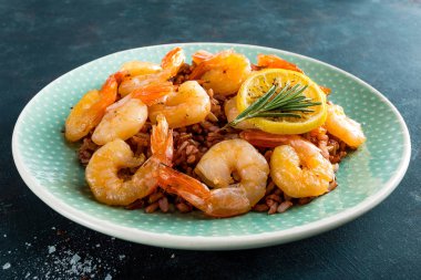 Karides ızgara kavrulmuş ve plaka üzerinde kahverengi pirinç haşlanmış. Izgara karides, karides pirinç. Deniz ürünleri. Asya mutfağı. Portre. Koyu arka plan