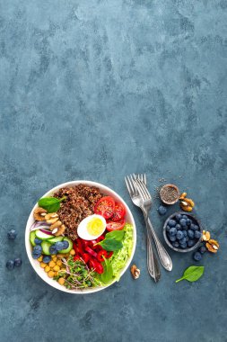 Buda kase yemek haşlanmış yumurta, nohut, taze domates, tatlı biber, salatalık, savoy lahana, kırmızı soğan, yeşil filizlenir, ıspanak yaprakları, yaban mersini, ceviz, chia ve quinoa. Sağlıklı yemek, yemek kase. Detoks diyet. Dengeli yemek. Üstten Görünüm