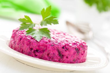 Haşlanmış pancar salatası. Kuru erik, ceviz ve ekşi krema beyaz zemin üzerine kırmızı pancar salatası