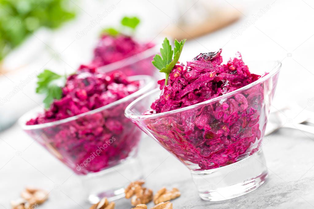 Beet salad. Salad of boiled beet. Beetroot salad with prune, walnuts and sour cream on white background