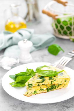 Ispanak yapraklı omlet. Tabakta omlet, çırpılmış yumurta.