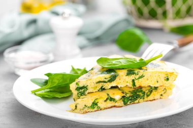 Ispanak yapraklı omlet. Tabakta omlet, çırpılmış yumurta.