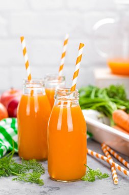 Taze havuç ve elma suyu beyaz arka plan üzerinde. Havuç ve elma suyu beyaz masada cam şişelerde. Beyaz arka plan üzerinde elma ve havuç suyu
