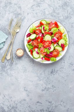 Domates, salatalık, tatlı biber ve susam ile taze sebze salatası. Beyaz tabakta sebze salatası