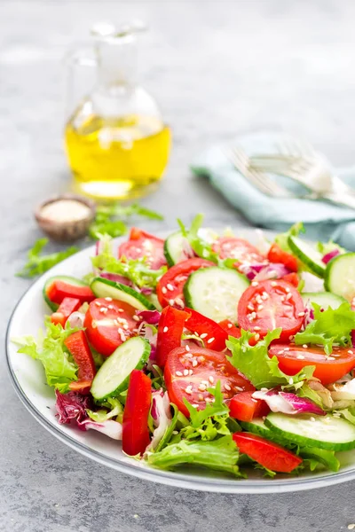 トマト キュウリ ピーマン 胡麻と新鮮な野菜のサラダ 白い皿の上の野菜のサラダ — ストック写真