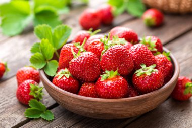 Çilek. Taze çilek ile ahşap masa yapraklarda