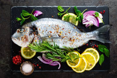 Taze dorado balık. Çiğ dorado balık ve gemide yemek pişirmek için madde. Çipura veya dorada balık Mutfak masasında