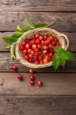 Kiraz. Taze tatlı kiraz ile sepete tahta masada bırakır.