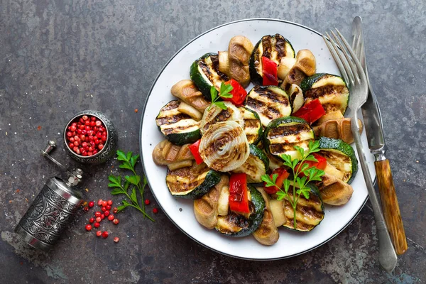 Salad with grilled vegetables and mushrooms. Vegetable salad with grilled champignons. Grilled salad on plate