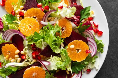 Haşlanmış pancar, kırmızı soğan, mandalina, nar, maydanoz, çam fıstığı ve marul yapraklı Noel salatası.