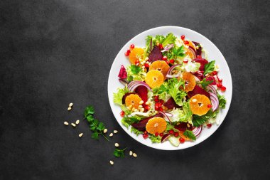 Haşlanmış pancar, kırmızı soğan, mandalina, nar, maydanoz, çam fıstığı ve marul yapraklı Noel salatası.