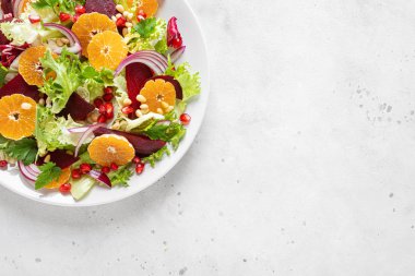 Haşlanmış pancar, kırmızı soğan, mandalina, nar, maydanoz, çam fıstığı ve marul yapraklı Noel salatası.